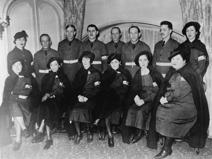 Somber-looking doctors and nurses in matching uniforms pose for a photograph