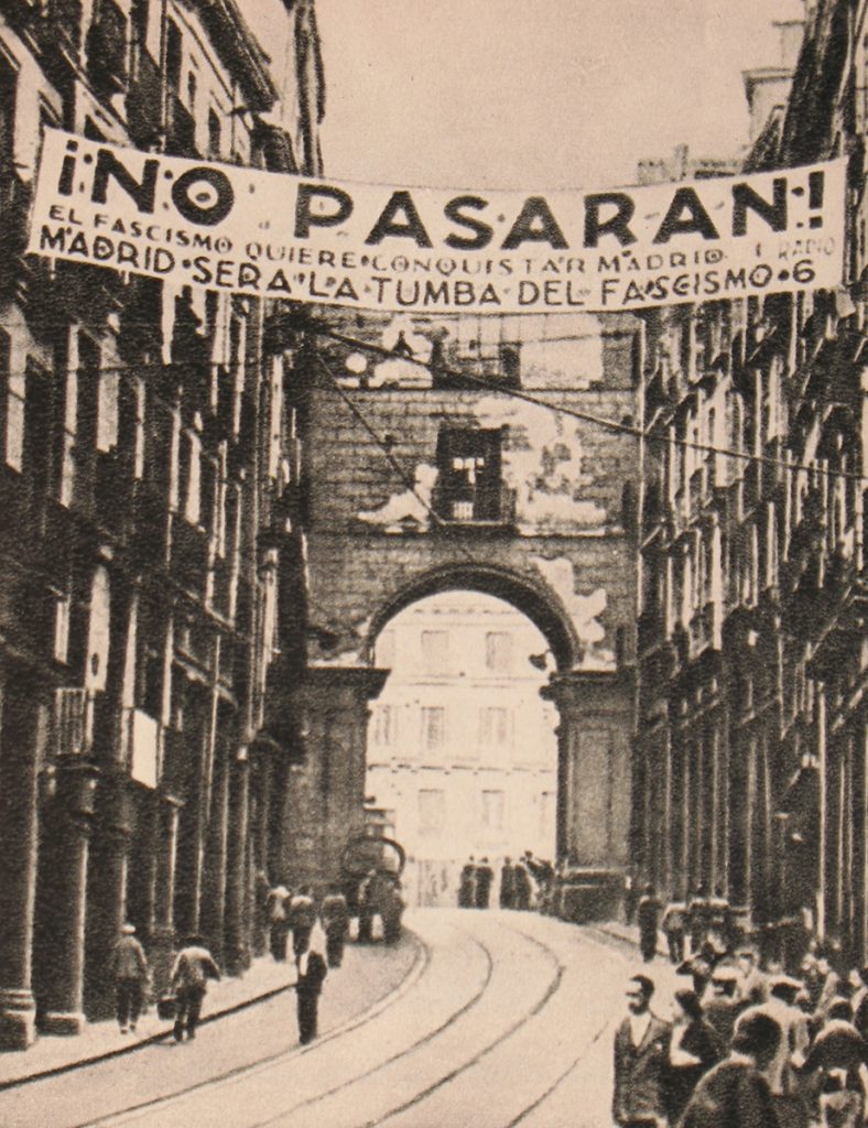An anti-fascist banner hangs above an ancient bridge and arterial in Madrid