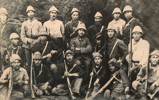 Black and white photograph of a group of soldiers bearing rifles