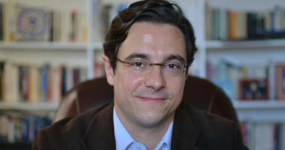 Dov Waxman, wearing a suit and glasses, from the shoulders up
