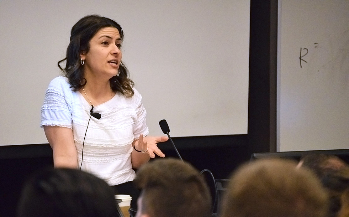 Hadar Khazzam-Horovitz standing at a podium in a full lecture hall