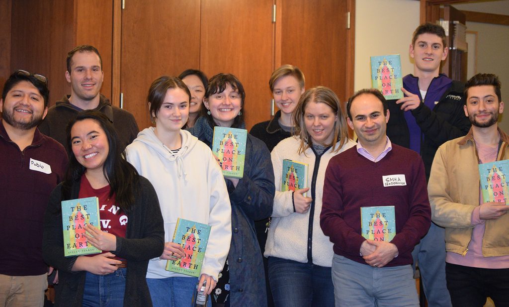 Group photo showing ten students, smiling and holding copies of "The Best Place on Earth" by Ayelet Tsabari alongside Professor Sasha Senderovich