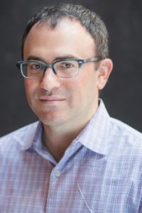 Daniel Schwartz in a button-down shirt and glasses
