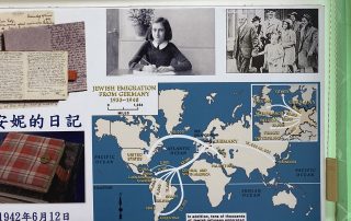 The Anne Frank exhibit at the Taiwan Holocaust Museum, showing black-and-white photographs of Anne Frank and her family, with captions in blue Chinese text