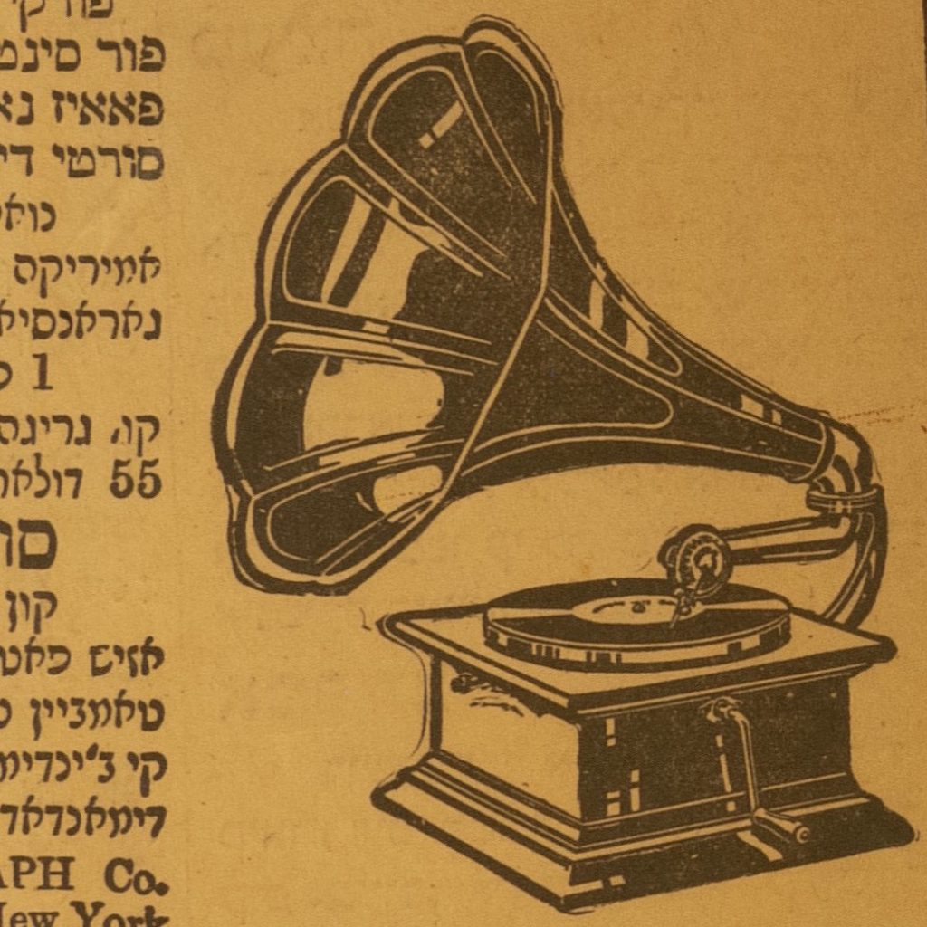 Ladino phonograph ad. Text on left side of ad, all written in Ladino in Hebrew characters. Right side of ad has a black illustration of a phonograph. The ad has a double outline border and the paper is a golden yellow color.
