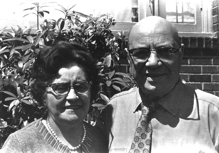 Black and white photo of Leo and Liza Azose with a bush in the background.