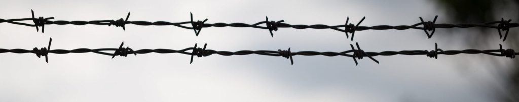 Photo of barbed wire above chain-link fence