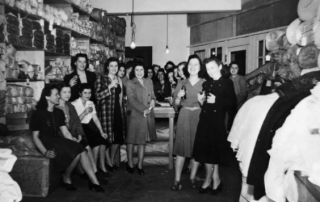 Black and white photograph of Seattle Curtain employees celebrating in stock area, Seattle, circa 1932-1941.