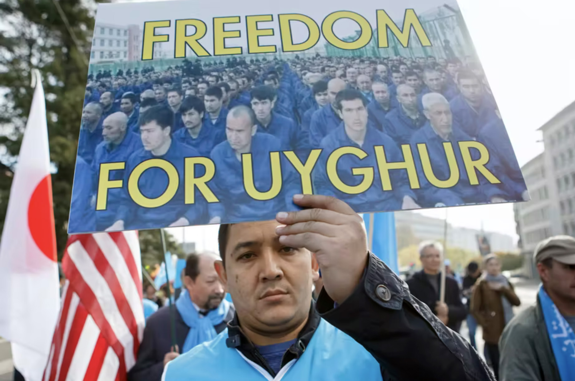 Man at protest holds up a "Freedom for Uyghurs" sign