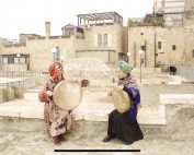 Ke Guo and Japanese musician Okaniwa Yayoi wearing bright traditional clothing and playing instruments in Jerusalem's Old City