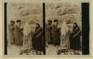 old sepia-toned photo of 2 men and 2 women praying at western wall