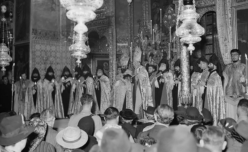 Black and white photo showing a religious ceremony with Armenian priests in the Cathedral of St. James in Jerusalem.
