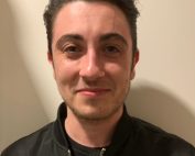 Portrait of Matthew Desmarais smiling in bomber jacket, hair slicked