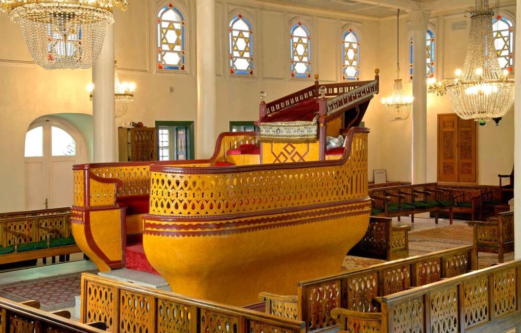 Synagogue interior, with boat-shaped raised platform (bima) in the center and windows with Star of David pattern