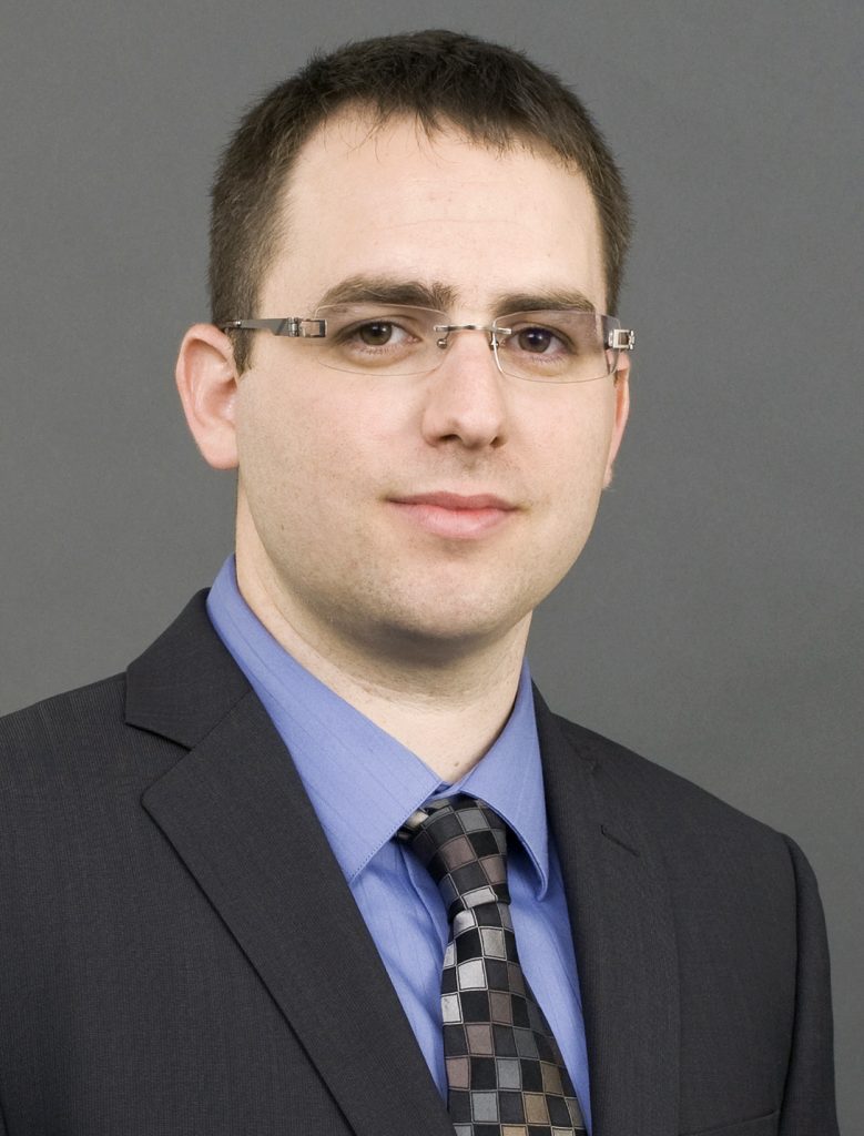 Doron Levit in suit, against gray backdrop