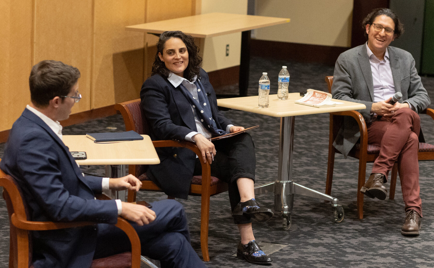 Two men and a woman sitting, in conversation.