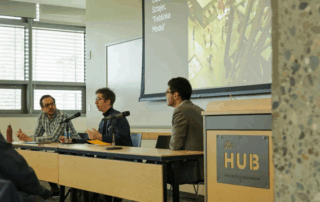 Three panelists seated at long table at the UW