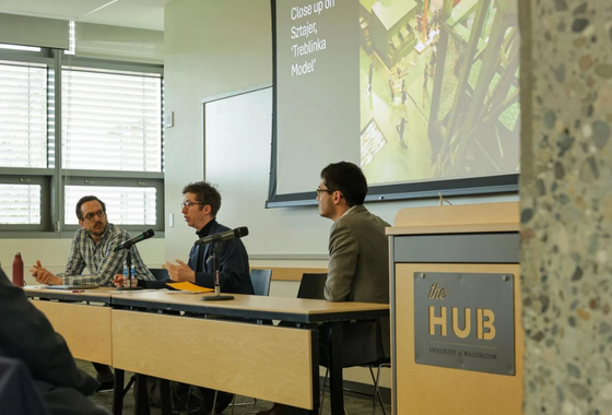 Three panelists seated at long table at the UW