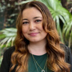 Woman in green shirt with long hair. 