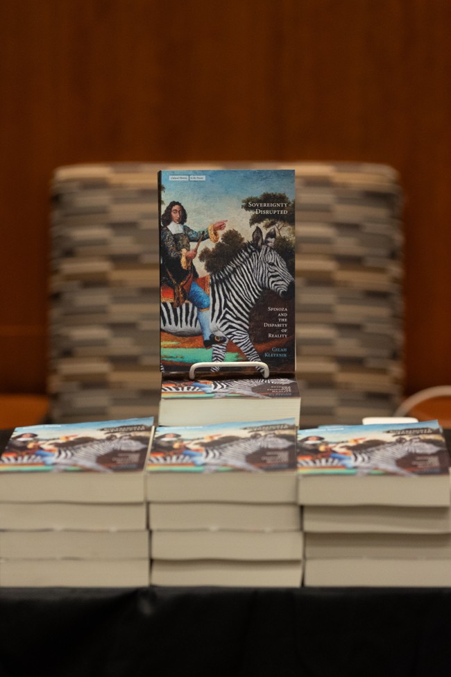 Copies of Sovereignty Disrupted are stacked on a table, with one book propped upright for display.