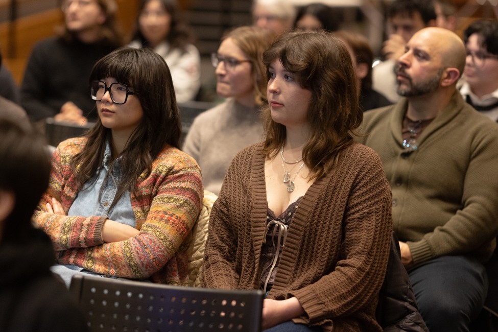 Audience members sit and listen during a public lecture or discussion.